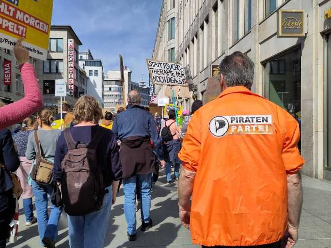 Thomas Ganskow mit oranger Piraten-Jacke von hinten als Teilnehmer des Demonstrationszuges durch die Innenstadt von Hannover.
